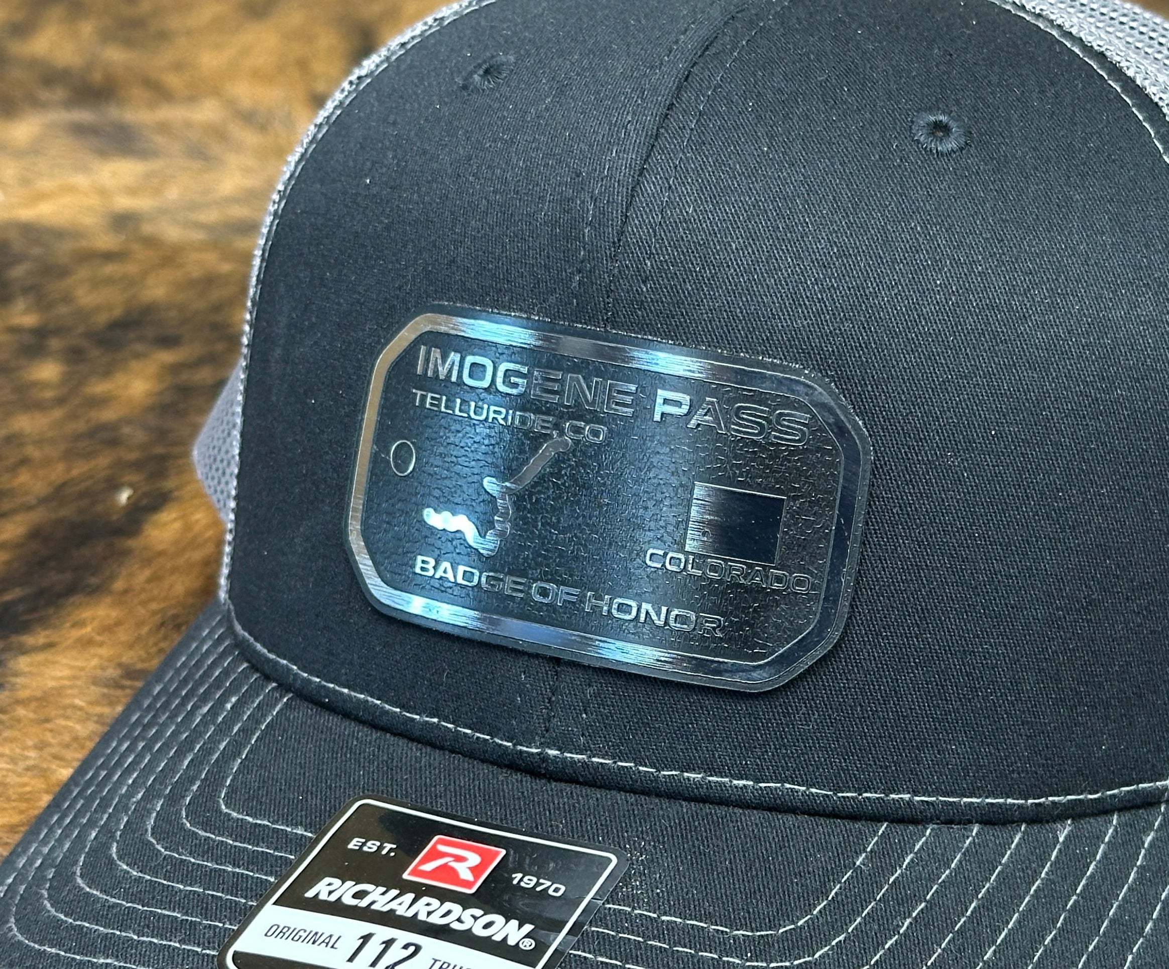 Black and gray hat with wholesale Acrylic patches with visible branding.