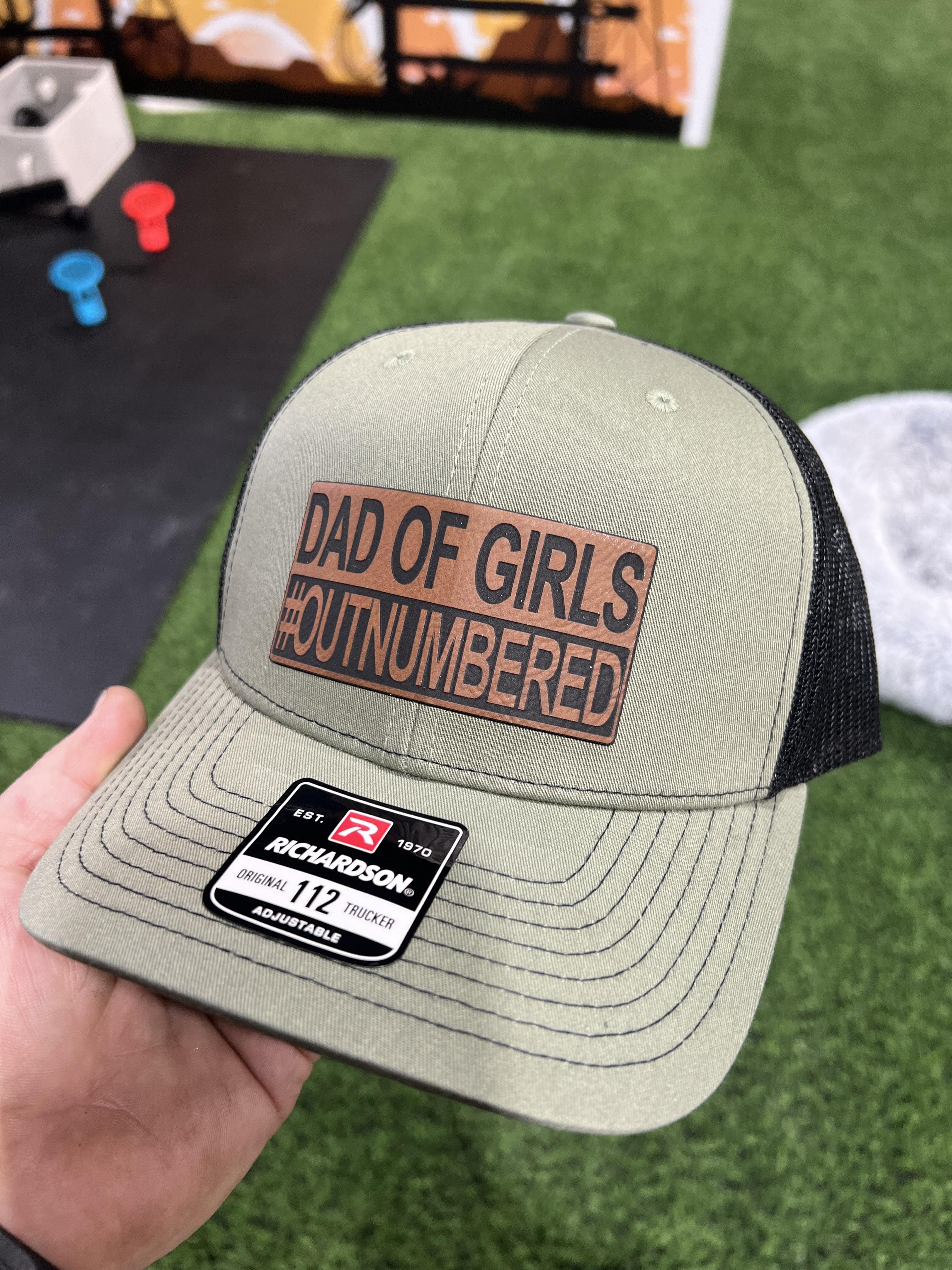 Dad of Girls OUTNUMBERED Leatherette Patch Hat is a Richardson 112 Trucker Hat with adjustable snapback. - F5 Custom Designs