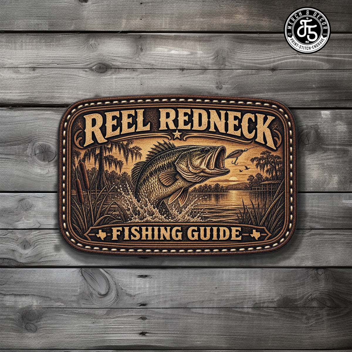A rectangular decorative UV Printed Hat Patch with rounded corners featuring a fishing illustration and the text 'REEL REDNECK FISHING GUIDE,' displayed against a gray wood plank background. A circular 'Real Fish & The Fish Company' logo appears in the top-right corner.