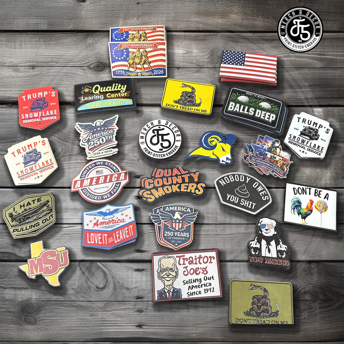 A collection of 20 Custom UV Printed Hat Patches with patriotic, conservative, and humorous designs arranged on a dark gray wood plank background. The UV Printed leatherette Hat patches feature various slogans, historical figures, and symbols like the Gadsden flag, the American flag, and Trump's Snowflake.