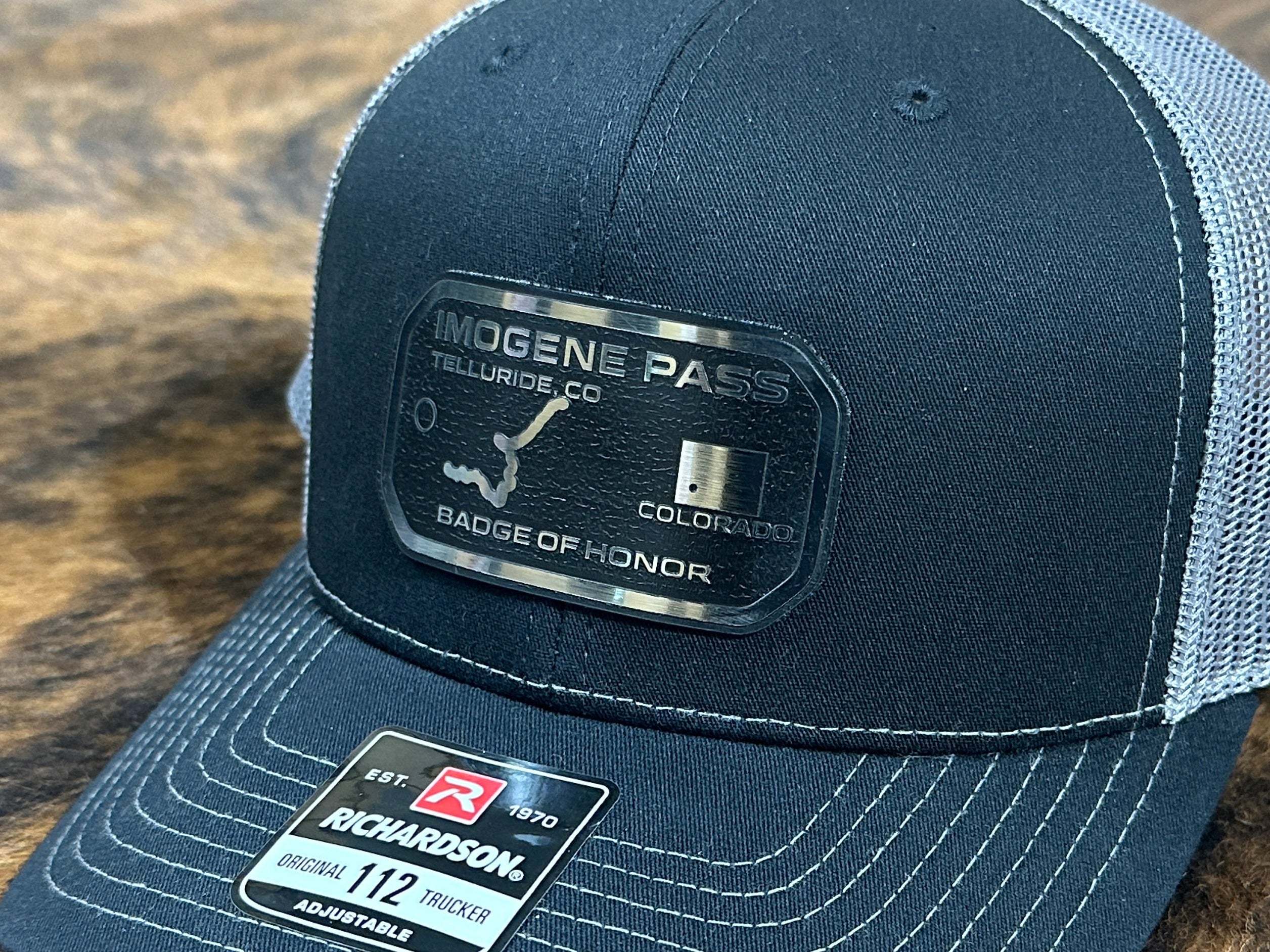 Black cap with whoelsale acrylic patches stainless with black engrave on a brown fur surface