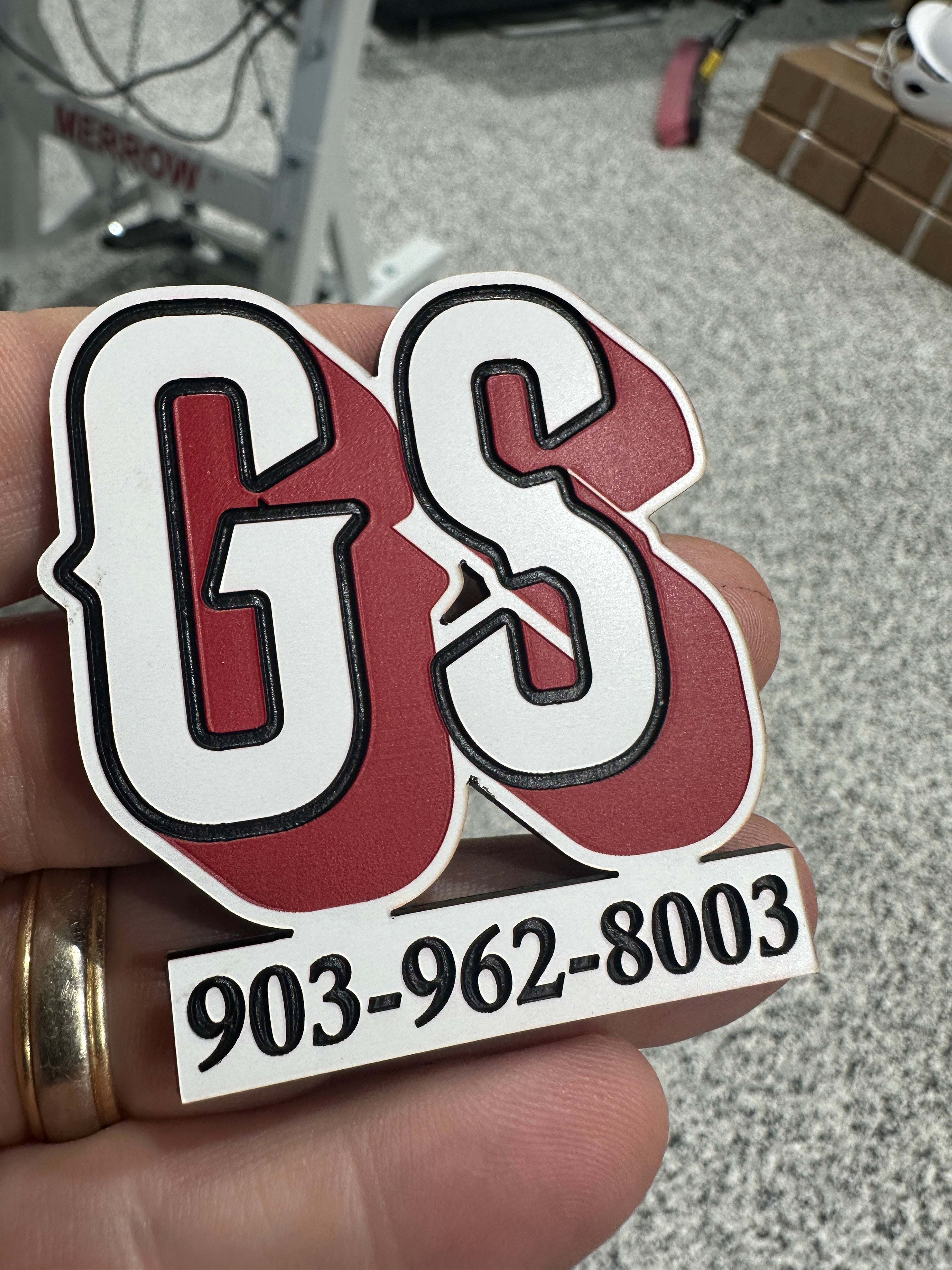 Hand holding a red and white engraved Wholesale acrylic patches