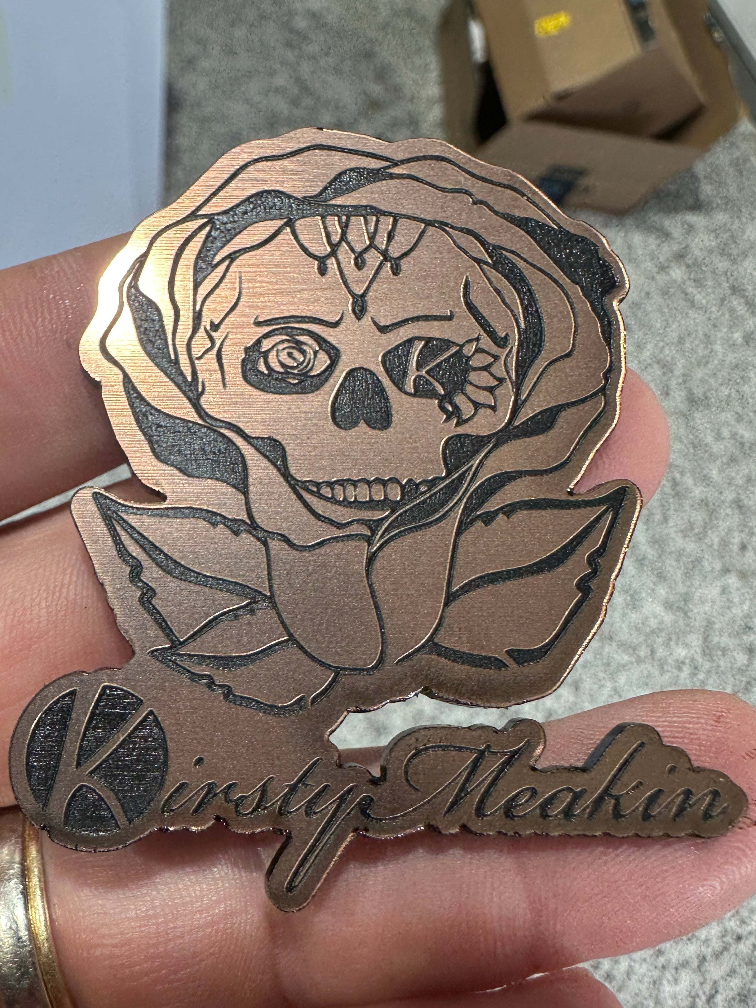 Rose gold-colored Wholesale Acrylic Patches with floral design held between fingers