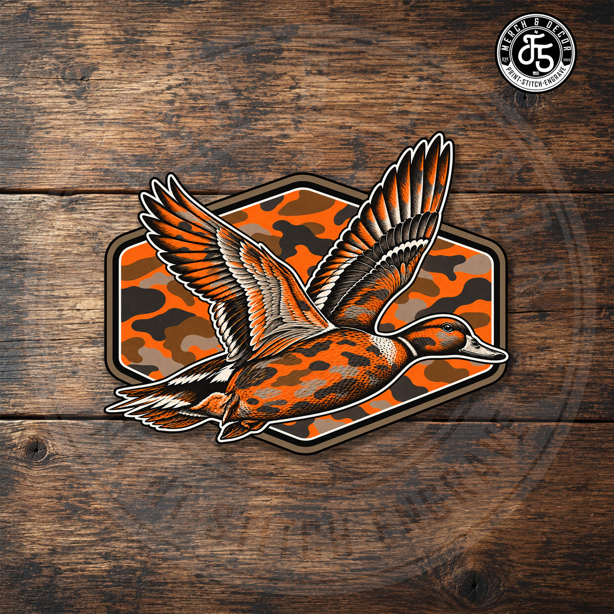 Blaze Flight orange Blaze Camo duck UV printed hat patch displayed on dark rustic wood.