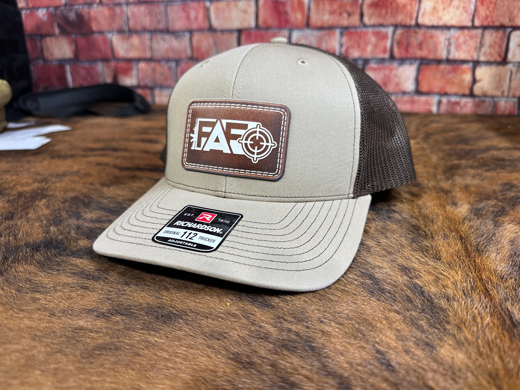 FAFO target patch Richardson 112 trucker hat shown from the front on a rustic surface