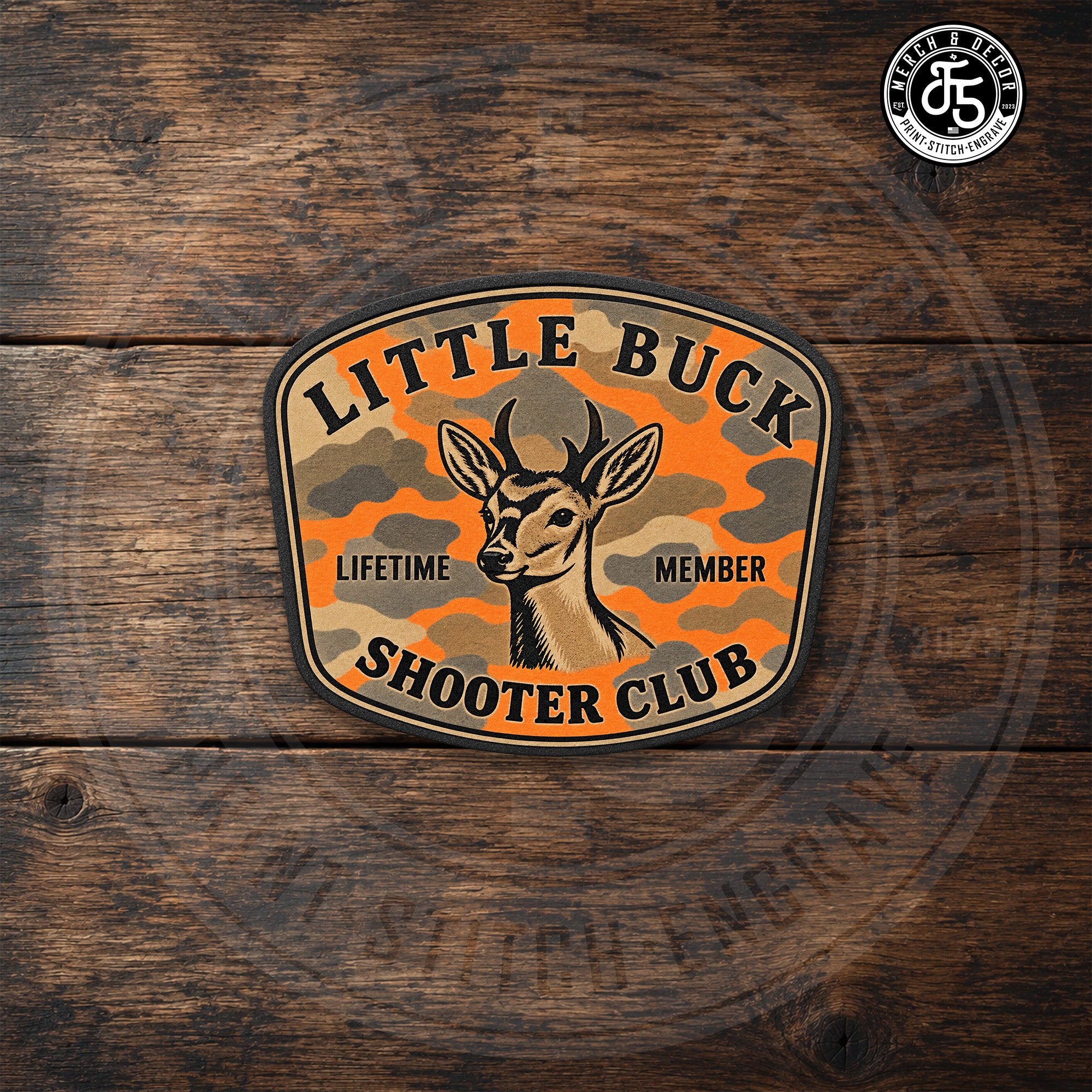 Little Buck Shooter Blaze Camo  UV printed hat patch displayed on dark rustic wood